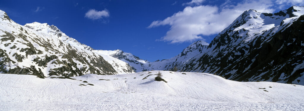 Italy, Valle d Aosta, Gran Paradiso National Park. Snow remains well into spring in the peaks of the landscape near Bardoney
