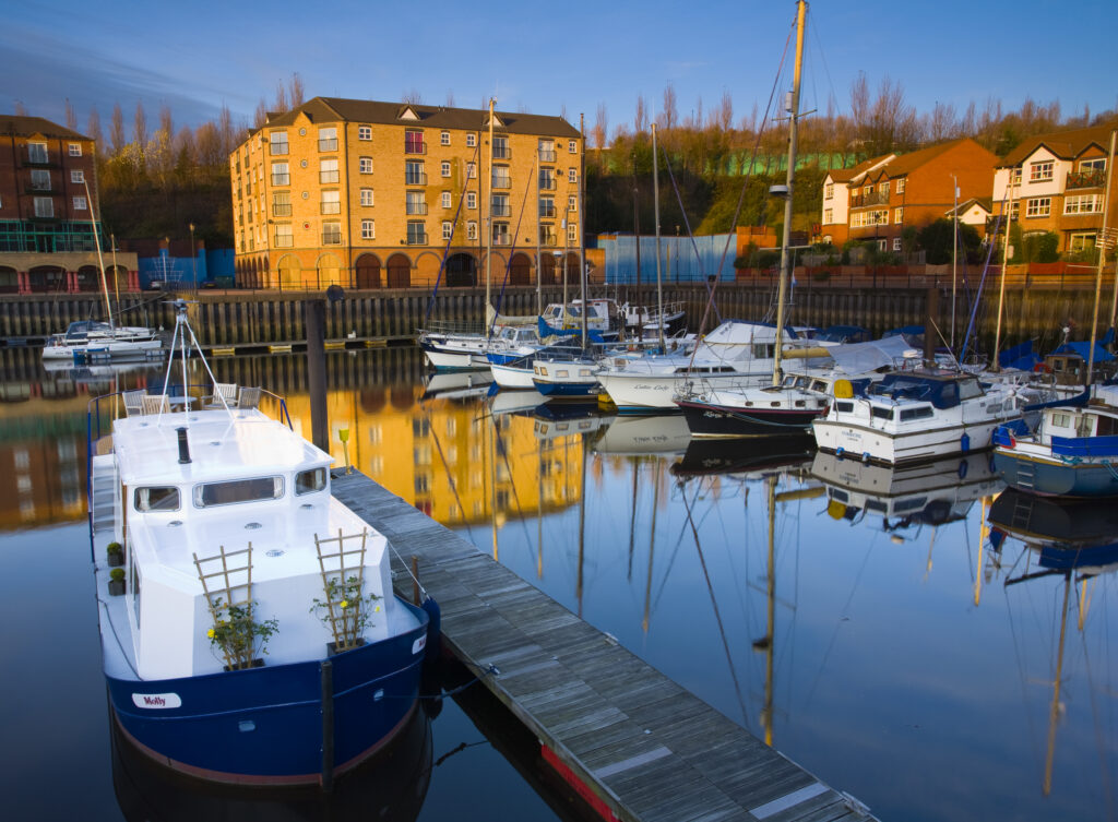 England, Tyne & Wear, Newcastle Upon Tyne. Reflections of moored boats and surrounding buildings in the St Peter's Basin.