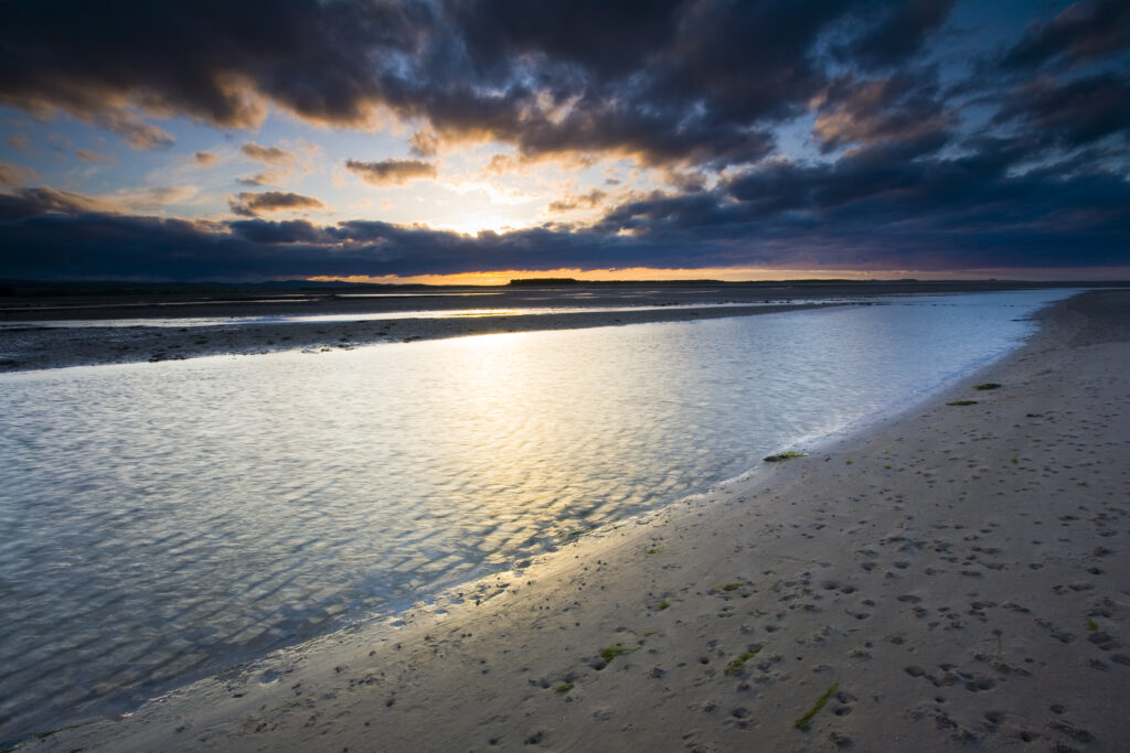 England, Northumberland, Budle Bay. Sunset over Budle Bay near Bamburgh, forming part of the Northumberland Heritage Coast.