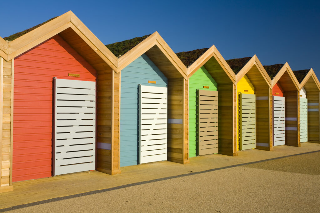England, Northumberland, Blyth. New colourful beach huts on the promenade at Blyth Beach.