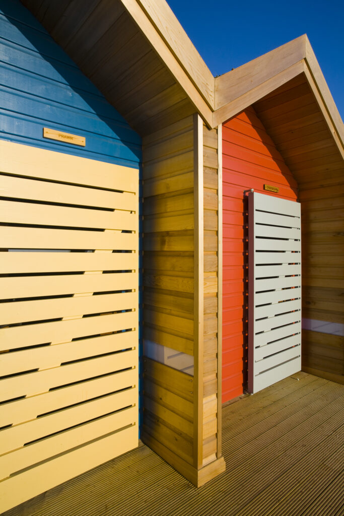 England, Northumberland, Blyth. New colourful beach huts on the promenade at Blyth Beach.