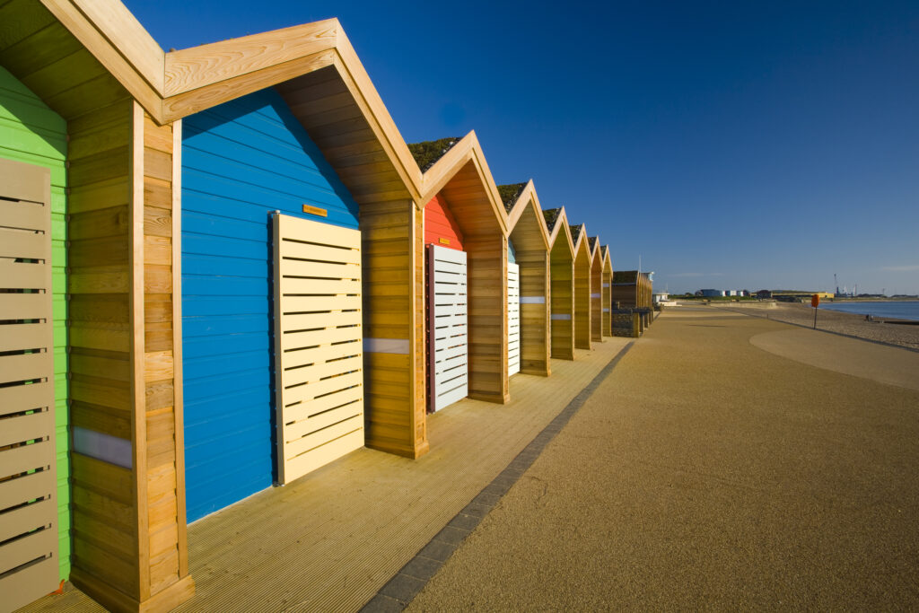 England, Northumberland, Blyth. New colourful beach huts on the promenade at Blyth Beach.