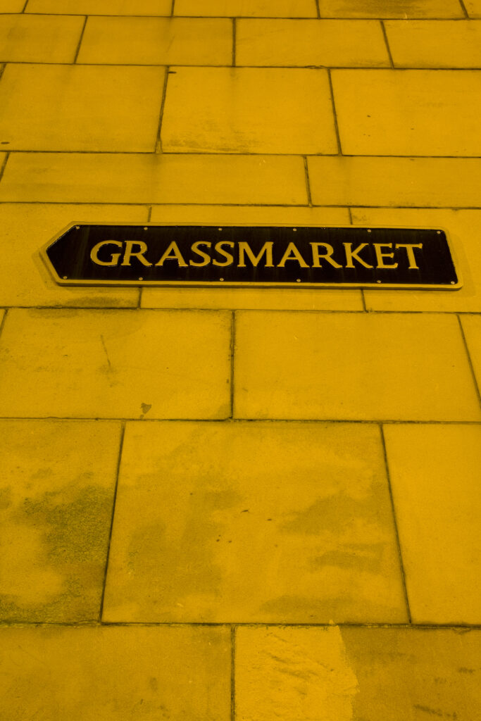 Scotland, Edinburgh, Edinburgh City. Sign on a wall pointing the direction to the Grassmarket.