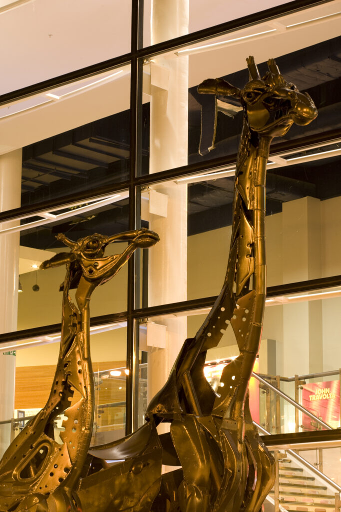 Scotland, Edinburgh, Omni Centre. These two giraffes that stand proud outside the Omni situated at Greenside Place, were created entirely out of scrap metal. They were titled Dreaming Spires by their designer Helen Denerley.