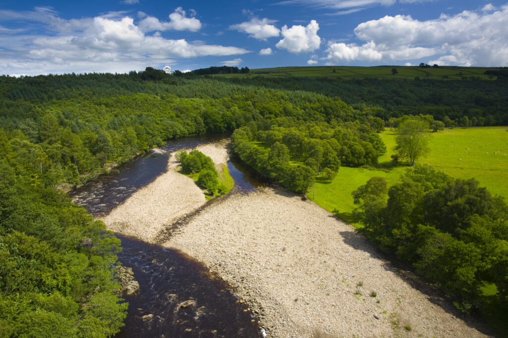 England, Northumberland, Lambley Viaduct. The River South Tyne flowing through a valley of woodland and fields, viewed from the Lambley Railway Viaduct.