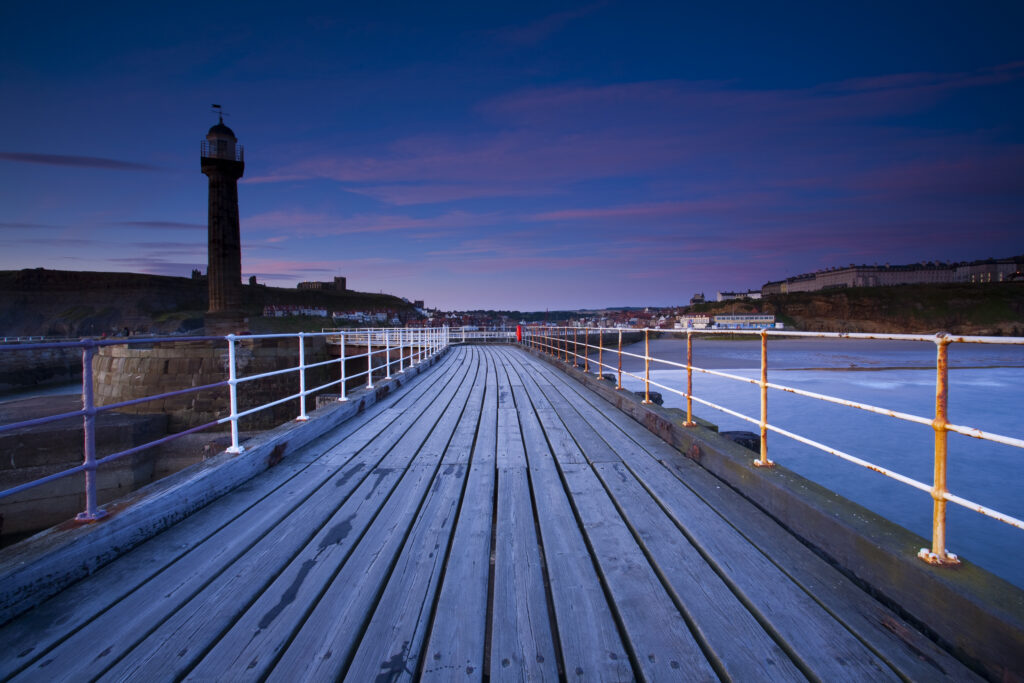 England, North Yorkshire, Whitby. Looking from the entrance piers of Whitby Harbour at dawn.