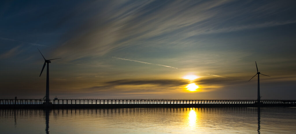 England, Northumberland, Blyth offshore wind farm. Sunrise silhouettes the Blyth offshore wind farm - wind turbines