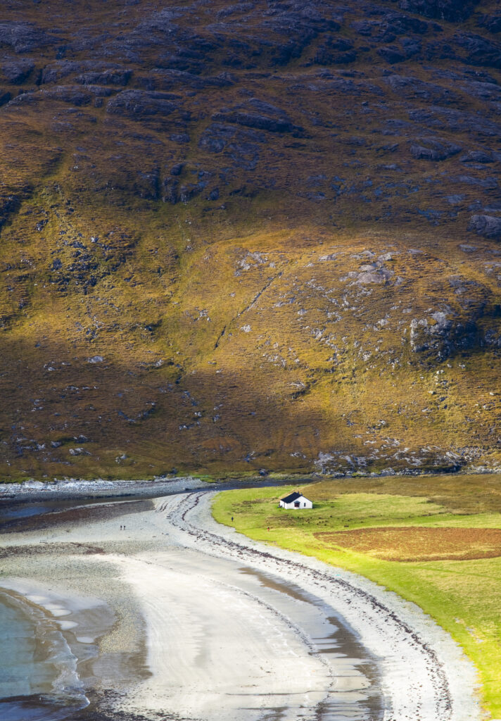 Scotland, Isle of Skye, Loch Scavaig. Breaking light on the lower hills of the Cuillin range and a cottage on the shores of Loch Scavaig.