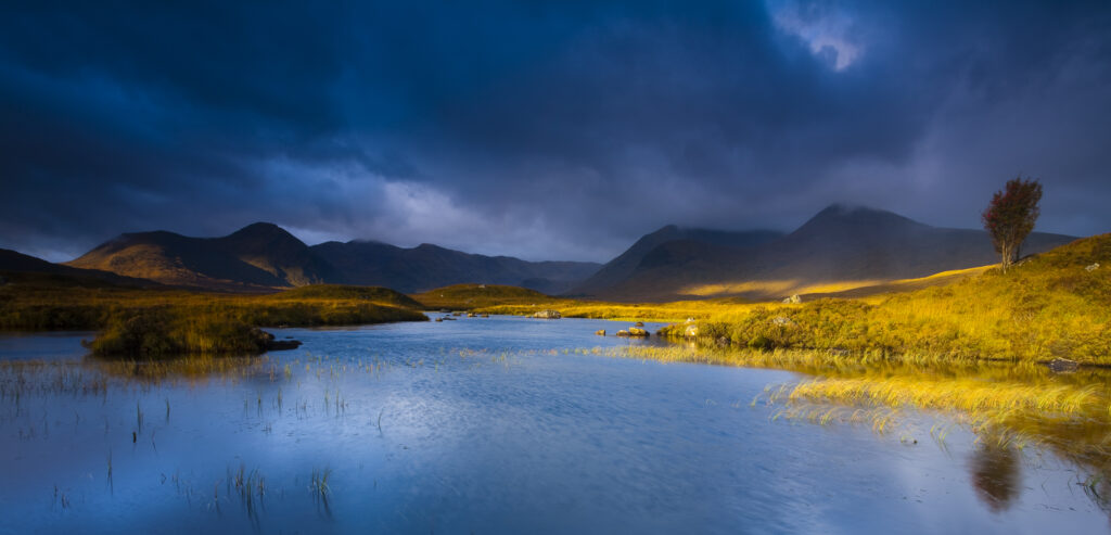 Scotland, Scottish Highlands, Rannoch Moor. Lochan an Stainge located on Rannoch Moor with the dominating peak of the Black Mount and surrounding mountains in the distance.
