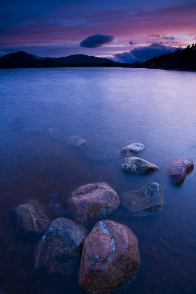 Scotland, Scottish Highlands, Cairngorms National Park. Deep red clouds above Loch Morlich and the surrounding mountains.
