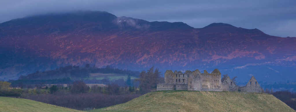 Scotland, Scottish Highlands, Cairngorms National Park. Dawn light bathes the Monadhliath Mountains overlooking the Ruthven Barracks.