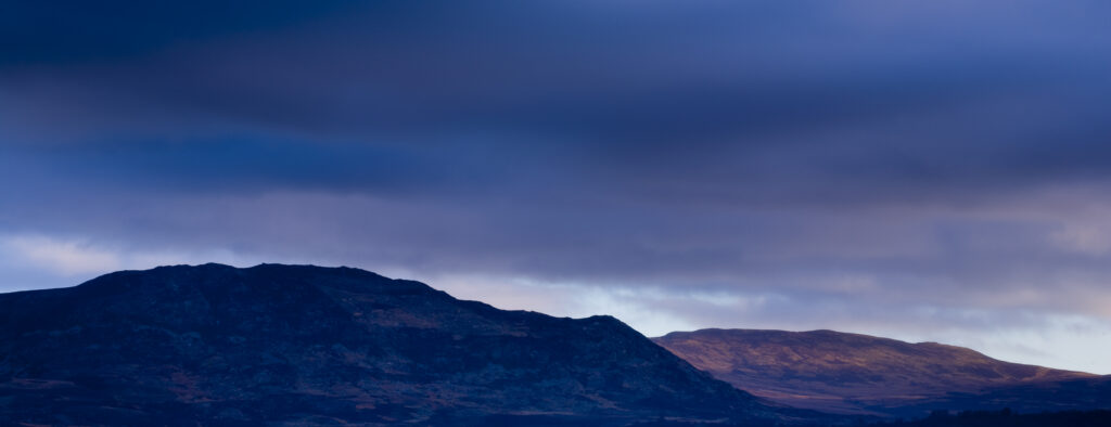 Scotland, Scottish Highlands, Cairngorms National Park. Storm clouds and soft dawn light on the mountains of the National Park.