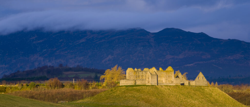 Scotland, Scottish Highlands, Cairngorms National Park. Dramatic light bathes the Ruthven Barracks, with the Monadhliath Mountains overlooking the ruins.