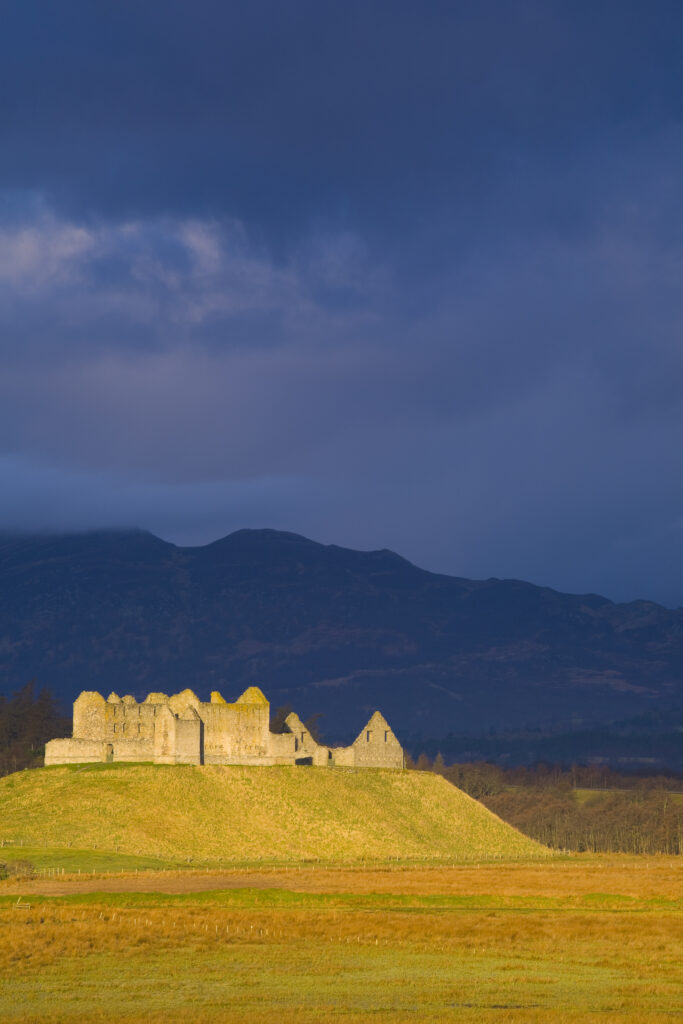 Scotland, Scottish Highlands, Cairngorms National Park. Dramatic light bathes the Ruthven Barracks, with the Monadhliath Mountains overlooking the ruins.