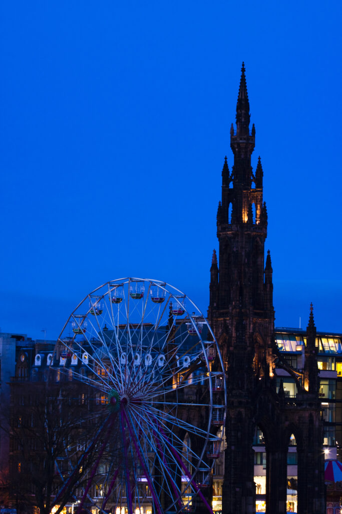 Scotland, Edinburgh, Princes Street. Ferris Wheel alongside the Monument to Sir Walter Scott.