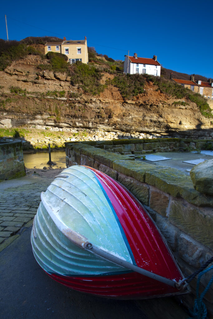 England, North Yorkshire, Staithes. Fishing boat moored near to a river in the old town of Staithes, located within the North York Moors National Park.