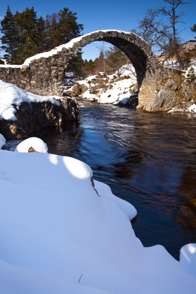 Scotland, Scottish Highlands, Cairngorms National Park. Old stone packhorse bridge over the River Dulnain at Carrbridge, The bridge was built in 1717 and is believed to be the oldest stone bridge to be found in the Highlands.