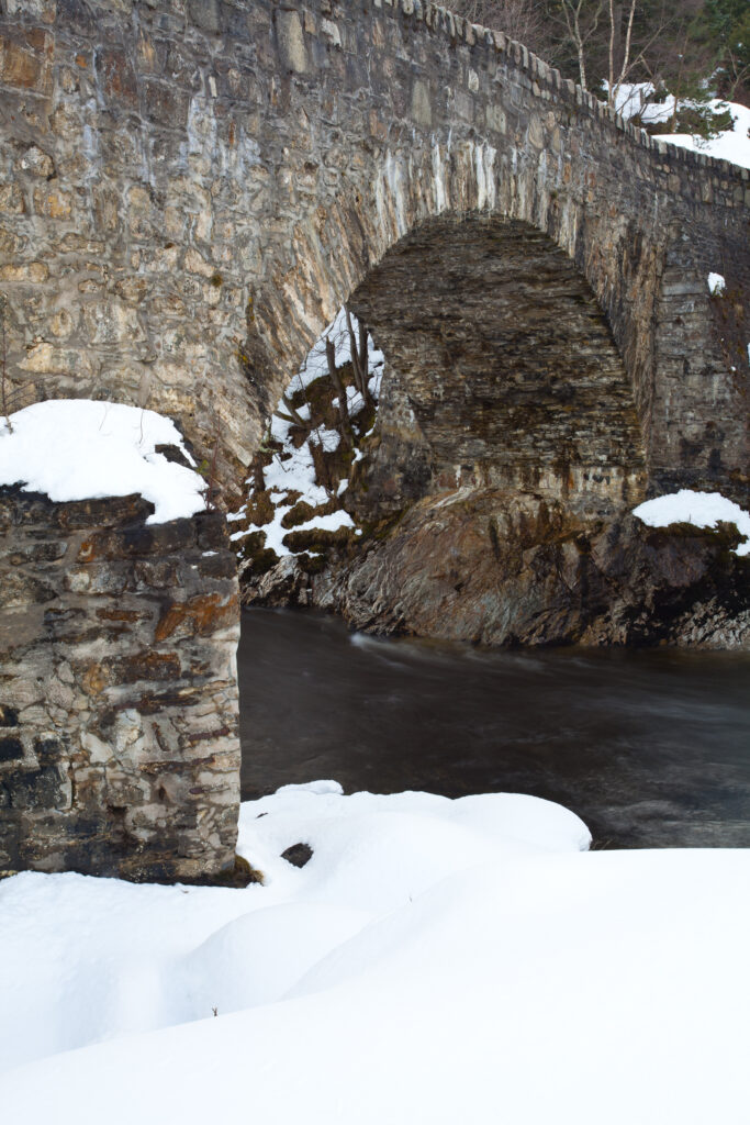Scotland, Scottish Highlands, Cairngorms National Park. The Bridge of Avon surrounded by a late winter covering of snow.