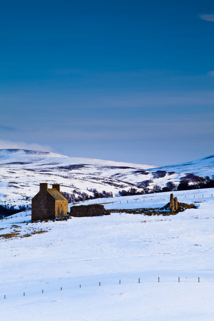 Scotland, Scottish Highlands, Cairngorms National Park. Derelict farm buildings on the snow covered hills near Tomintoul.
