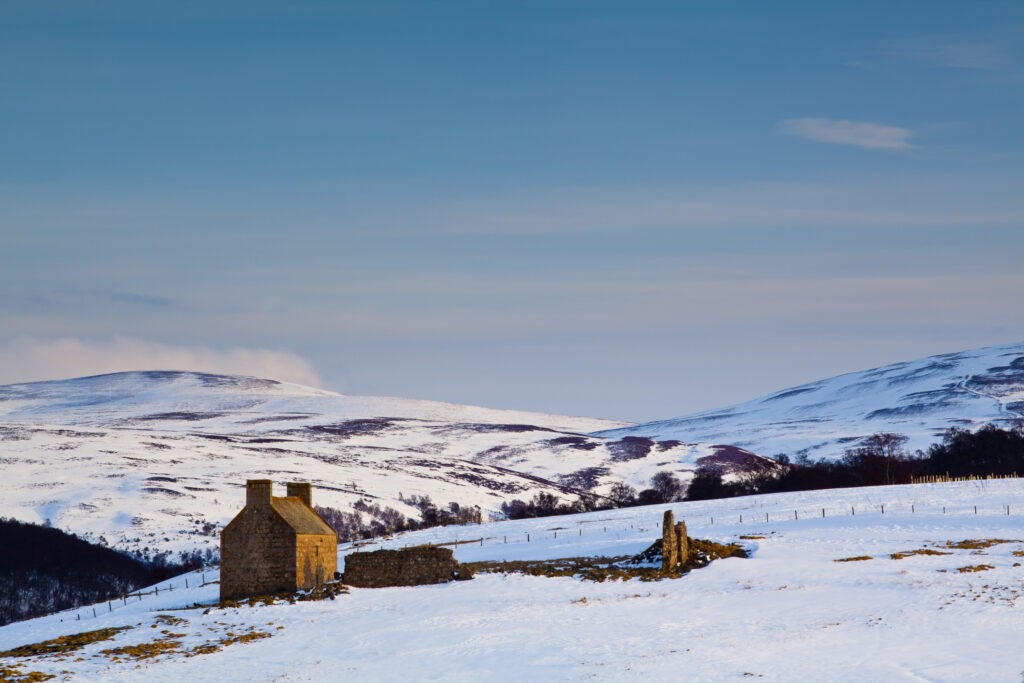 Scotland, Scottish Highlands, Cairngorms National Park. Derelict farm buildings on the snow covered hills near Tomintoul.