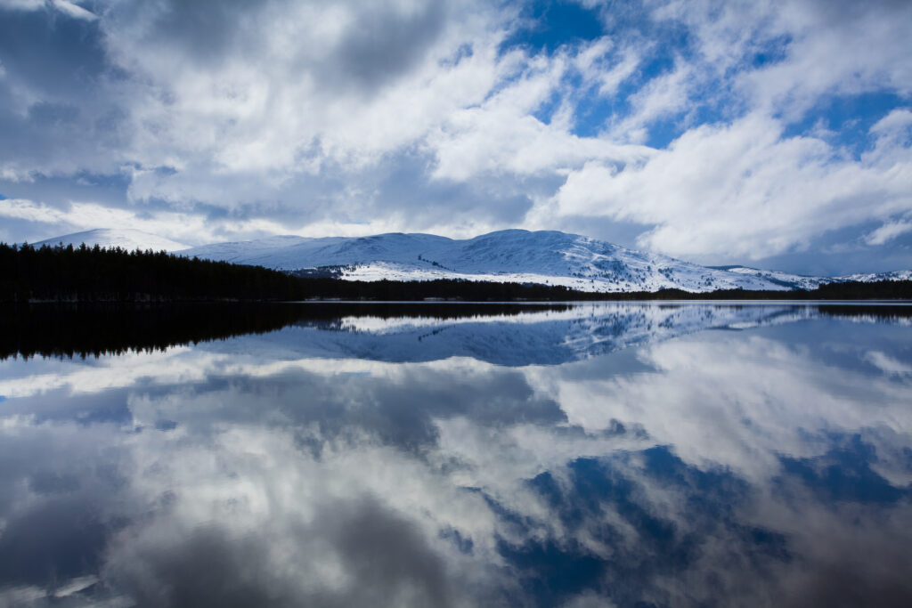 Scotland, Scottish Highlands, Cairngorms National Park. Clearing storm reflected on the still waters of Loch Garten.