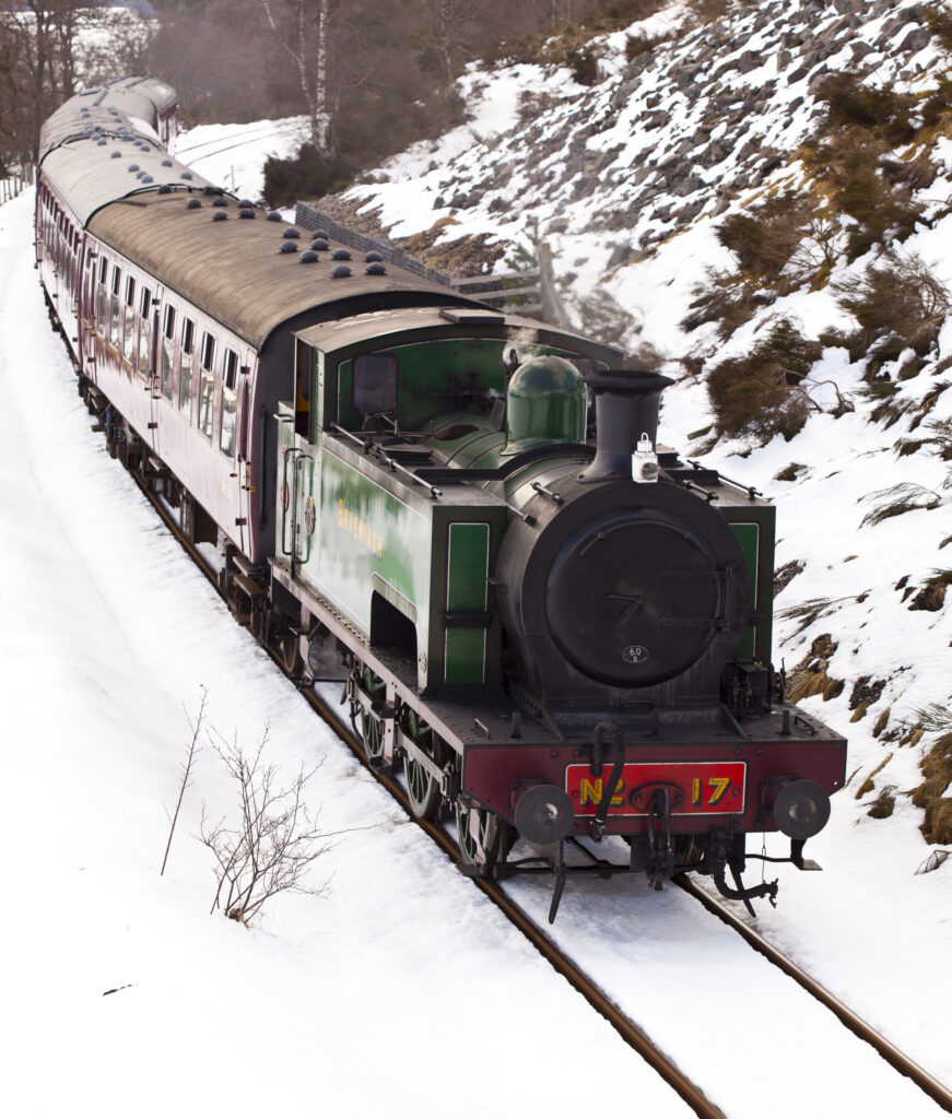 Scotland, Scottish Highlands, Cairngorms National Park. Strathspey steam railway engine and carriages, running along the track near Broomhill.