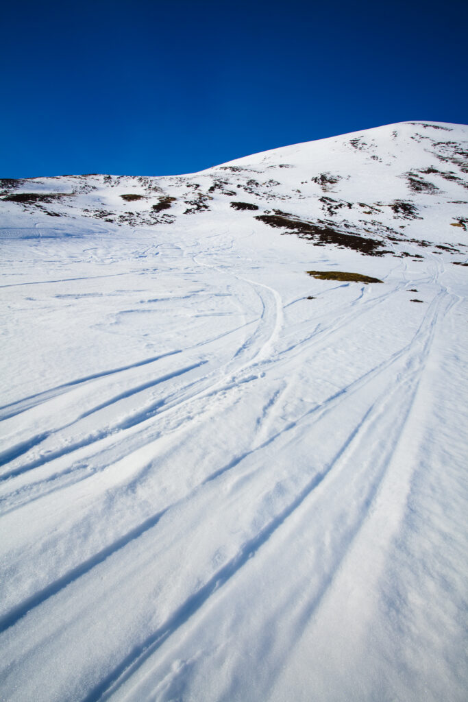 Scotland, Perthshire, Glenshee. Ski and snowboard tracks on the snow covered slopes of the Glenshee Ski Area.