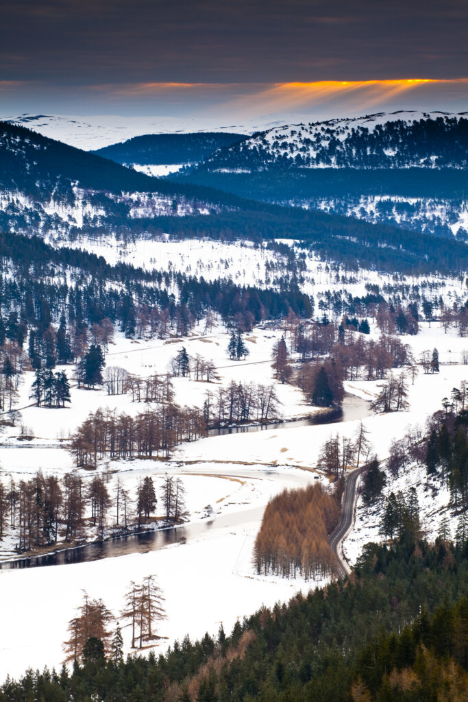 Scotland, Scottish Highlands, Cairngorms National Park. The River Dee meandering through snow covered fields and mountains near Braemar.