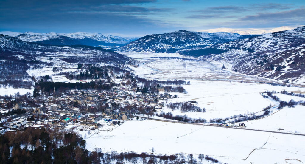 Scotland, Scottish Highlands, Cairngorms National Park. The highland village of Braemar and surrounding snow covered fields and mountain peaks. Braemar is the highest and most mountainous parish to be found in the UK.