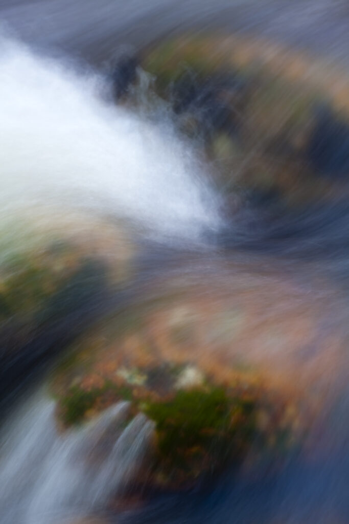 Scotland, Scottish Highlands, Cairngorms National Park. Water falling over boulder in a river located in the Rothiemurchus Estate.