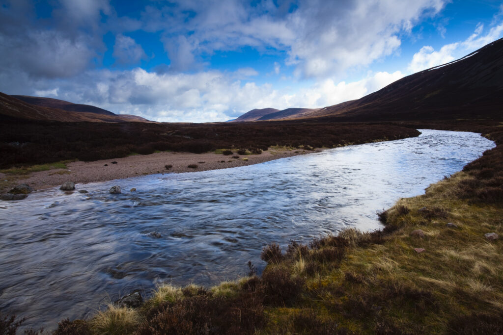 Scotland, Scottish Highlands, Cairngorms National Park. River running through the heather clad hills of Gleann Eanaich, in the Rothiemurchus Estate.