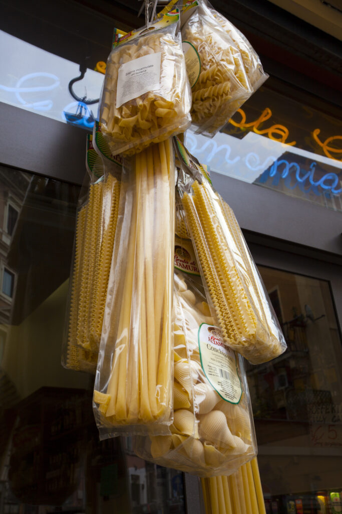 Italy, Lazio, Rome. Bags of dried pasta hanging outside a store in Rome City.
