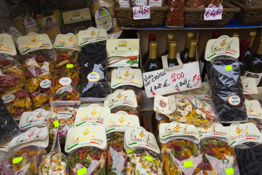 Italy, Lazio, Rome. Bags of dried pasta, wine and other italian produce on display outside a store in Rome City.