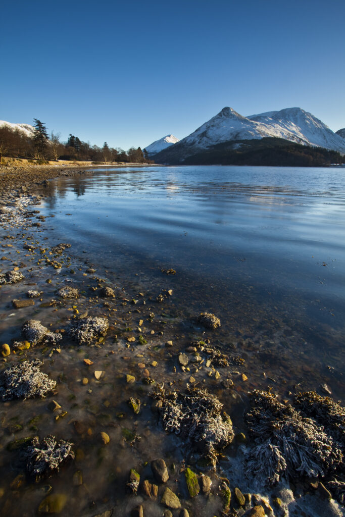 Scotland, Scottish Highlands, Loch Leven. The frost covered shoreline of Loch Leven, looking towards the Pap of Glencoe (Sgorr na Ciche).