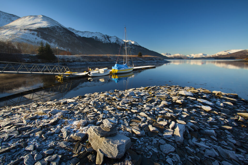 Scotland, Scottish Highlands, Ballachulish. Sailing boats moored on Loch Leven, looking towards Beinn Bhan, Sgorr Bhan and Sgorr Dhearg.