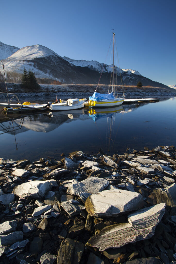 Scotland, Scottish Highlands, Ballachulish. Sailing boats moored on Loch Leven, looking towards Beinn Bhan, Sgorr Bhan and Sgorr Dhearg.