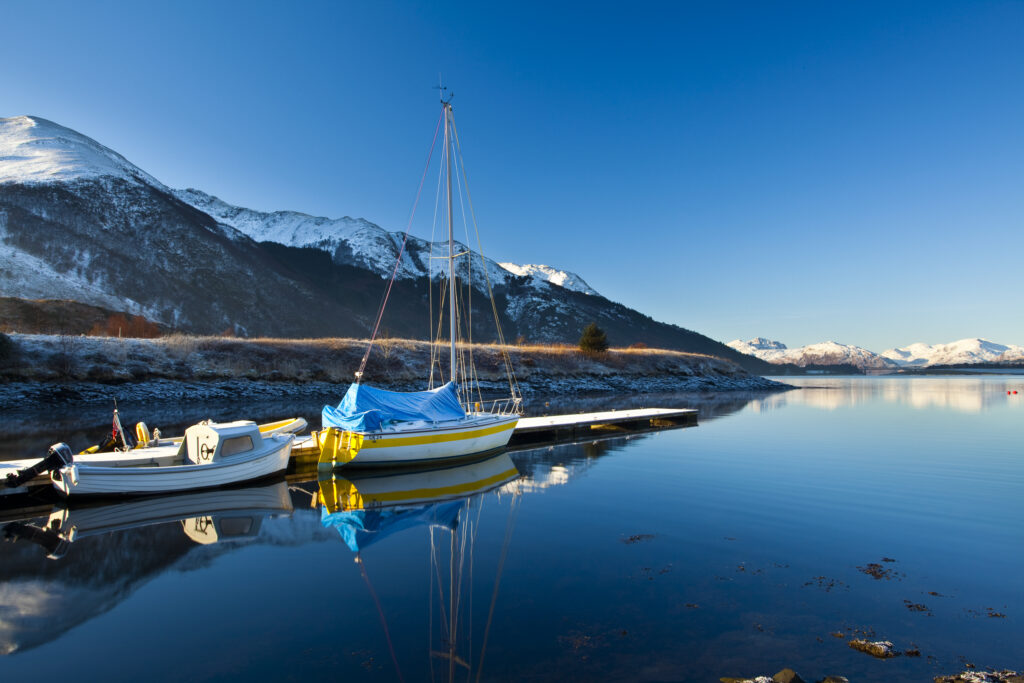 Scotland, Scottish Highlands, Ballachulish. Sailing boats moored on Loch Leven, looking towards Beinn Bhan, Sgorr Bhan and Sgorr Dhearg.