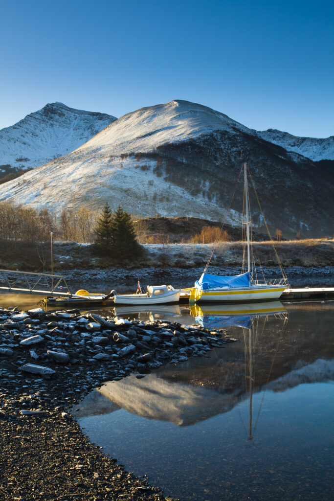 Scotland, Scottish Highlands, Ballachulish. Sailing boats moored on Loch Leven, looking towards Beinn Bhan, Sgorr Bhan and Sgorr Dhearg.