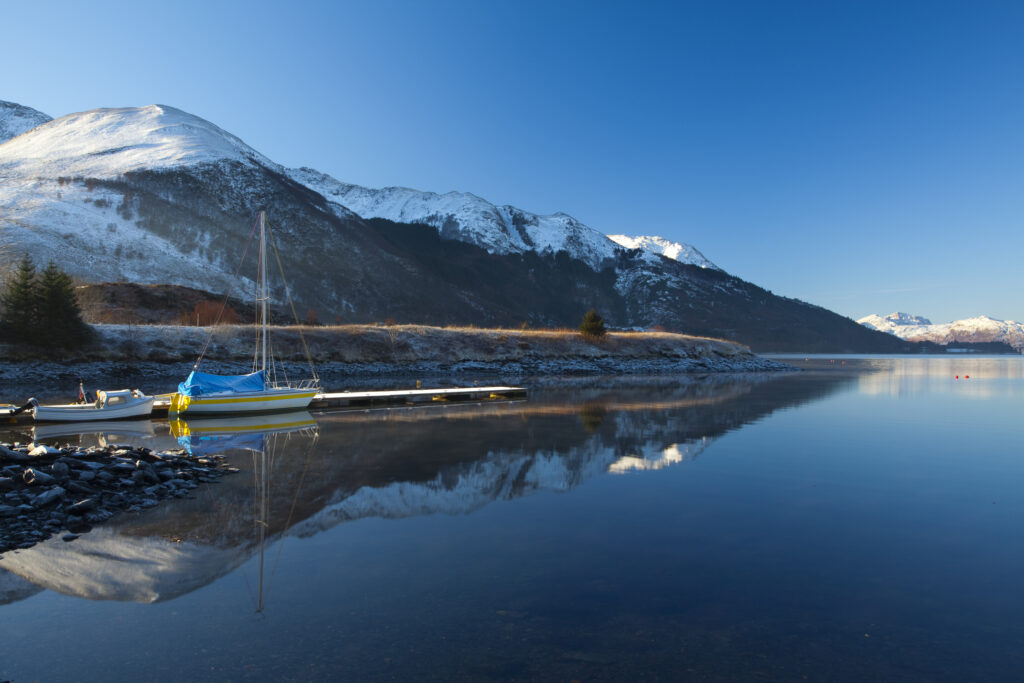 Scotland, Scottish Highlands, Ballachulish. Sailing boats moored on Loch Leven, looking towards Beinn Bhan, Sgorr Bhan and Sgorr Dhearg.