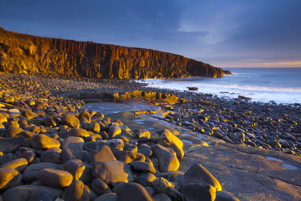 England, Northumberland, Cullernose Point. Dawn light illuminates the rocky shoreline of Cullernose Point, near the village of Craster on the Northumberland Heritage Coast.