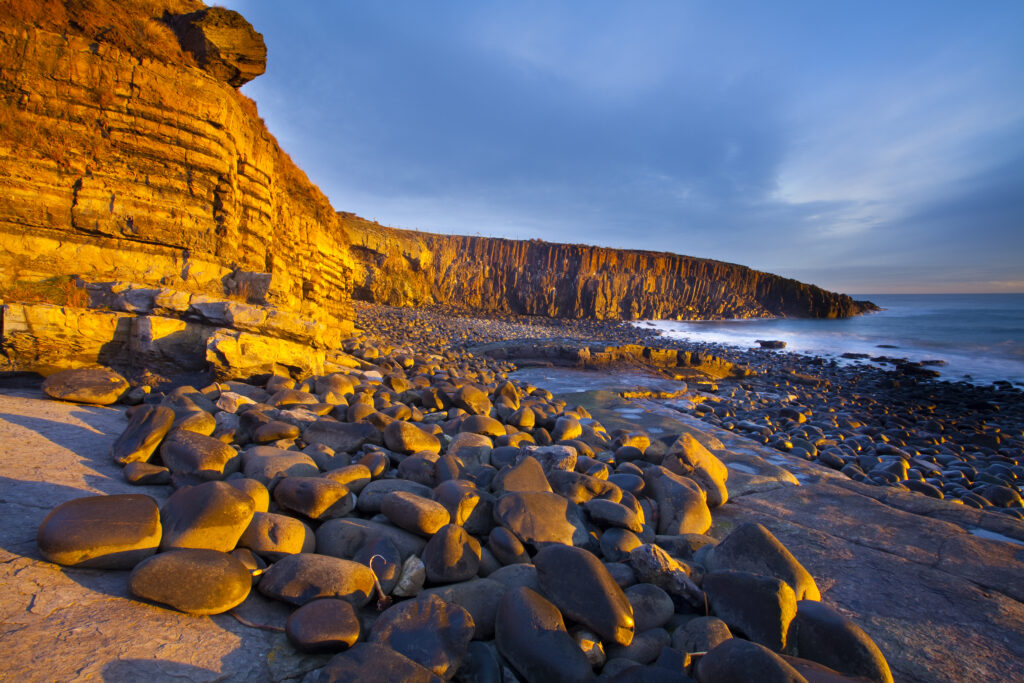 England, Northumberland, Cullernose Point. Dawn light illuminates the rocky shoreline of Cullernose Point, near the village of Craster on the Northumberland Heritage Coast.