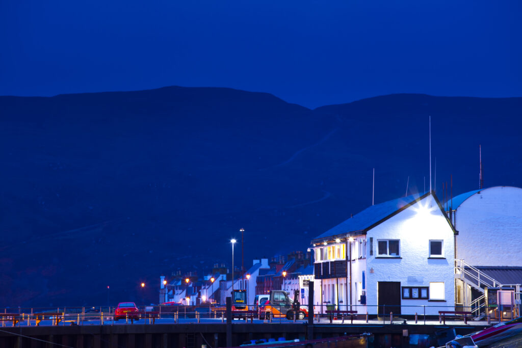 Scotland, Scottish Highlands, Ullapool. Local houses under the shadow of a mountain overlooking the busy port at Ullapool on the shores of Loch Broom.