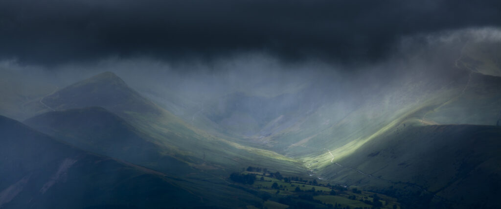 England, Cumbria, Lake District National Park. Breaking light through storm clouds above the Northern Fells near the Newlands Valley close to Keswick.