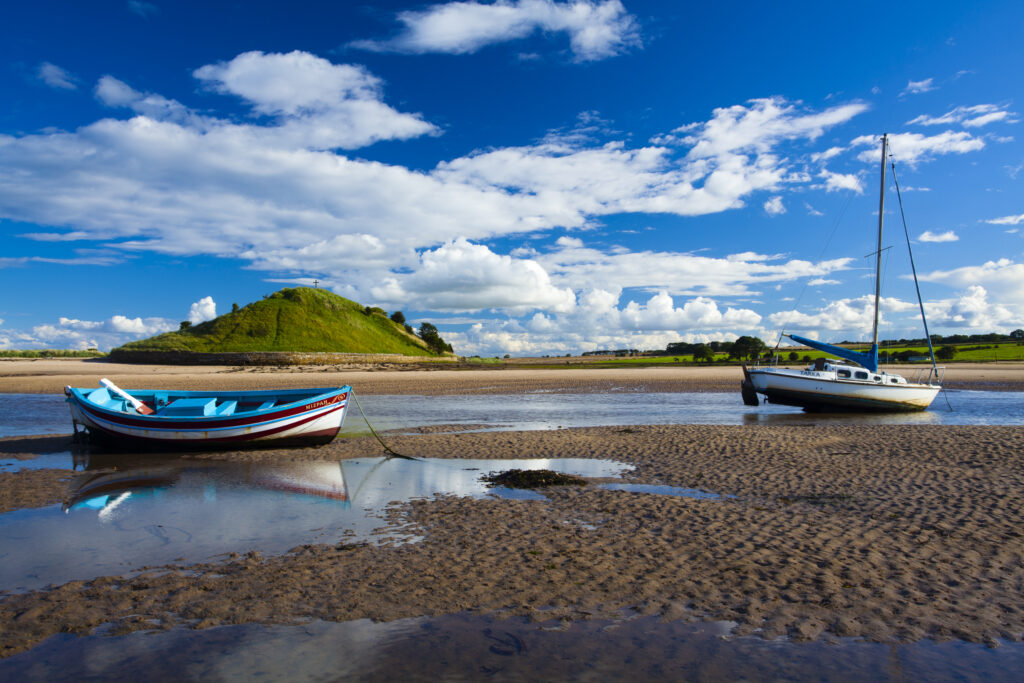 England, Northumberland, Alnmouth. Boats on the tidal Aln Estuary at Alnmouth. The hill in the distance is known as Church Hill.