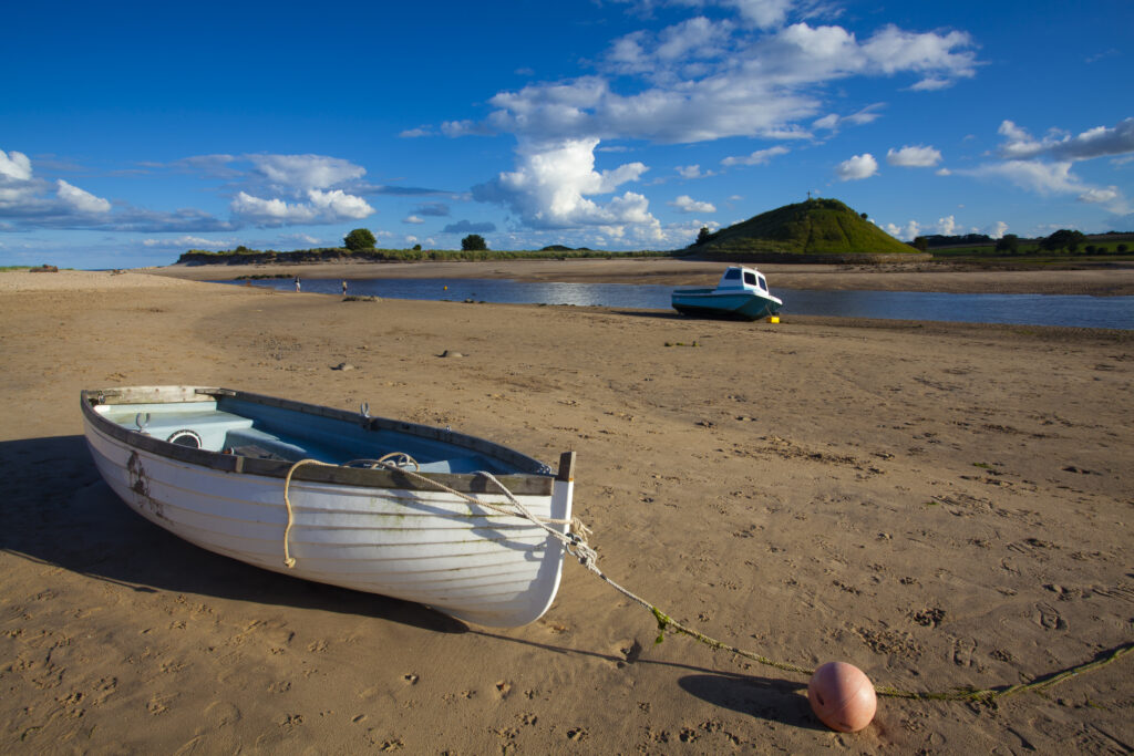 England, Northumberland, Alnmouth. Boats on the tidal Aln Estuary at Alnmouth. The hill in the distance is known as Church Hill.