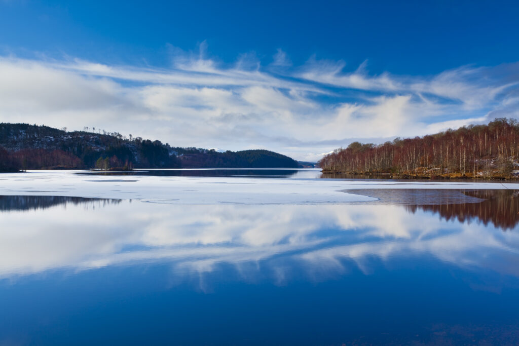 Scotland, Scottish Highlands, Loch Garry. Cloud formations reflected upon the mirror like face of Loch Garry.