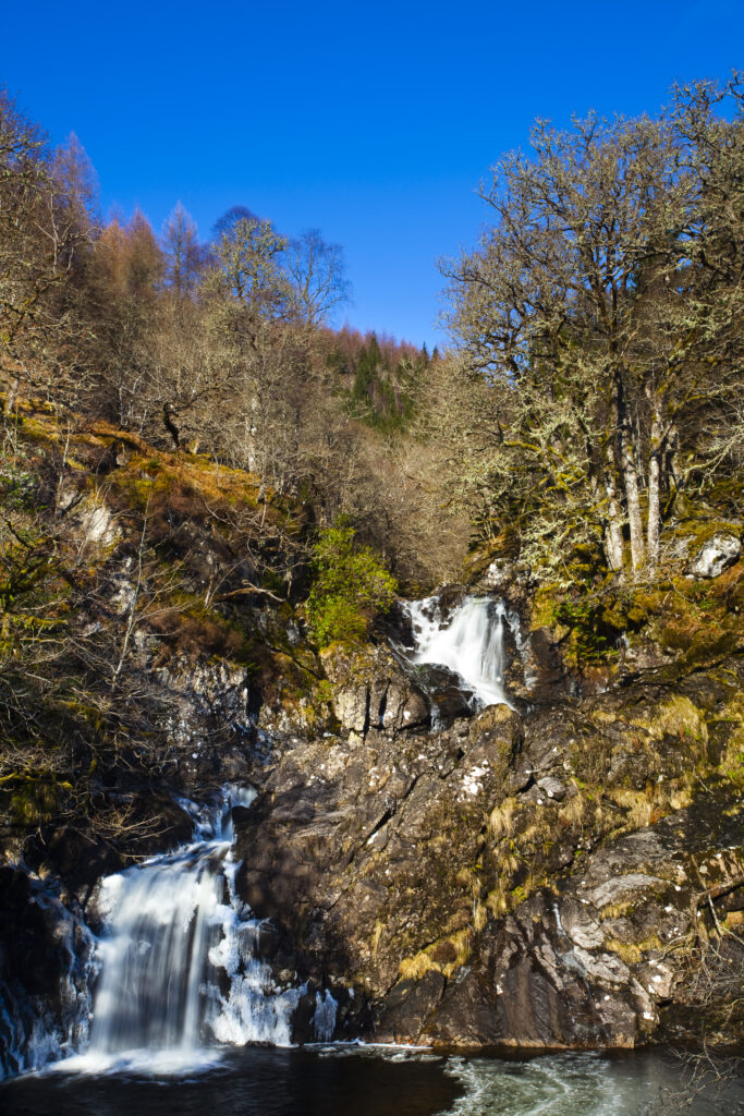 Scotland, Scottish Highlands, Eas Chia-aig waterfall. The Eas Chia-aig waterfall running through a tranquil expanse of native woodland.