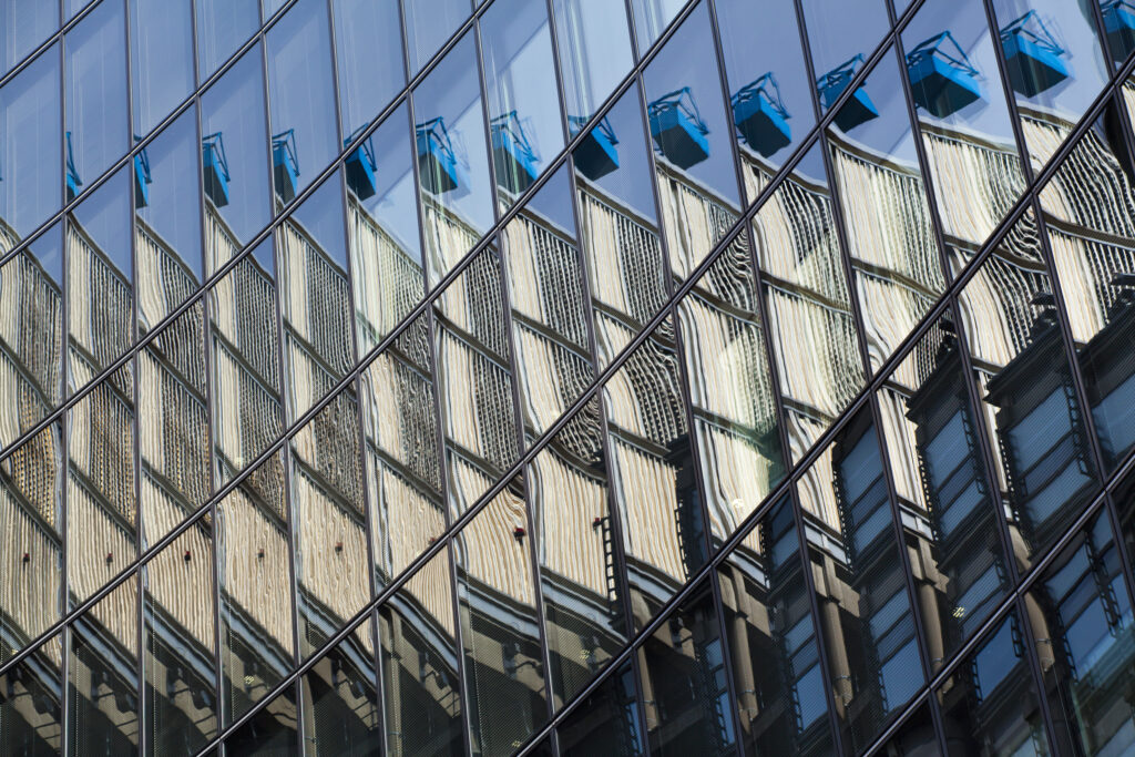 England, Greater London, The City of London. Abstract view of the modern architecture of the financial square mile in the City of London. Here the Lloyds building is reflected upon the mirror face of nearby offices.