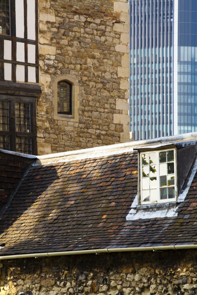 England, Greater London, London Borough of Tower Hamlets. Old and modern buildings, part of the Tower of London Complex with the financial district in the distance.