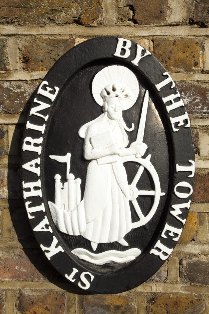 England, Greater London, London Borough of Tower Hamlets. St Katharine by the Tower plaque near the entrance to the St Katharine Docks, on the north bank of the River Thames near the London Tower Bridge.
